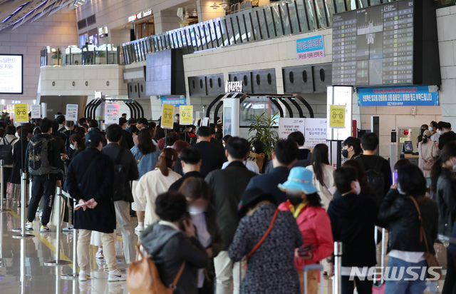 [서울=뉴시스]고승민 기자 = 지난 18일 서울 강서구 김포공항 국내선 청사에서 탑승객들이 출국 수속을 하기 위해 긴 줄을 서고 있다. 2021.04.21. kkssmm99@newsis.com