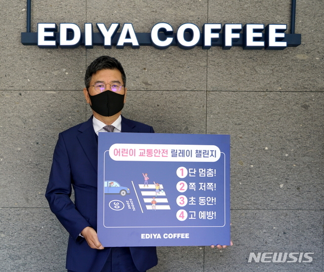 [서울=뉴시스] 20일 이디야커피 문창기 회장이 ‘어린이 교통안전 릴레이 챌린지’에 동참하며 어린이 교통안전 표어를 소개하고 있다.(사진=이디야커피 제공)