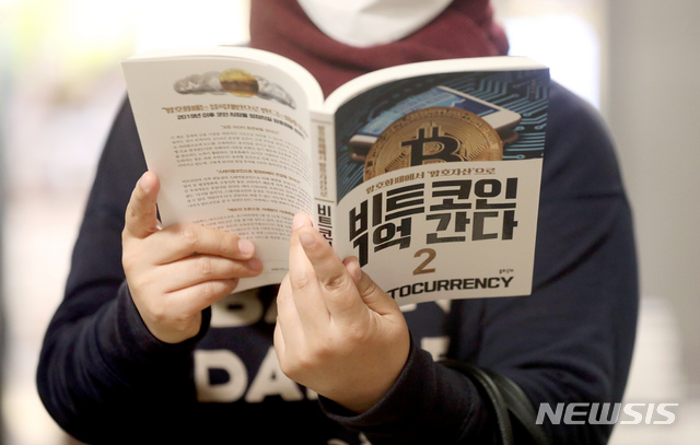 [서울=뉴시스]김병문 기자 = 20일 오전 서울 시내 한 대형서점에서 한 시민이 암호화폐 서적을 살펴보고 있다. 2021.04.20. dadazon@newsis.com
