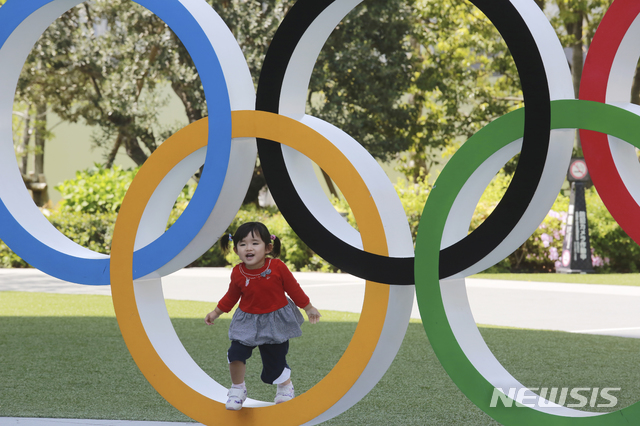 [도쿄=AP/뉴시스]지난 20일 일본 도쿄에서 한 어린이가 올림픽을 상징하는 오륜 조형물에서 놀고 있다. 2021.04.22.