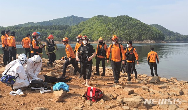 [청주=뉴시스]이민우 기자 = 21일 충북 청주시 문의면 문의대교 인근에서 119구급대원들이 추락 헬기 탑승자를 구조하고 있다. 2021.04.21. lmw3837@newsis.com