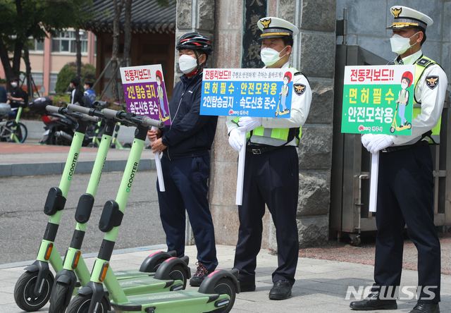 [전주=뉴시스]김얼 기자 = 전주시 자전거정책과 관계자들과 전주 덕진경찰서, 완산경찰서 경찰관들이 21일 전북 전주시 전북대학교 구정문 앞에서 개인형 이동 장치(PM) 안전이용문화 정착을 위한 합동 캠페인을 하고 있다. 2021.04.21. pmkeul@newsis.com