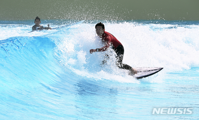 [시흥=뉴시스]김종택 기자 = 낮 기온이 28도까지 오르는 등 초여름 날씨를 보인 지난 21일 오후 경기도 시흥시 인공 서핑시설 '웨이브 파크'에서 서퍼들이 파도를 타고 있다. 2021.04.21. jtk@newsis.com