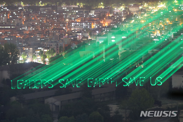 [서울=뉴시스]박주성 기자 = 국제환경단체 그린피스가 '세계기후정상회의'를 하루 앞둔 21일 오후 한국을 포함한 세계 정상들에게 보내는 메시지를 서울 남산면에 새기는 퍼포먼스를 진행하고 있다. 2021.04.21. park7691@newsis.com
