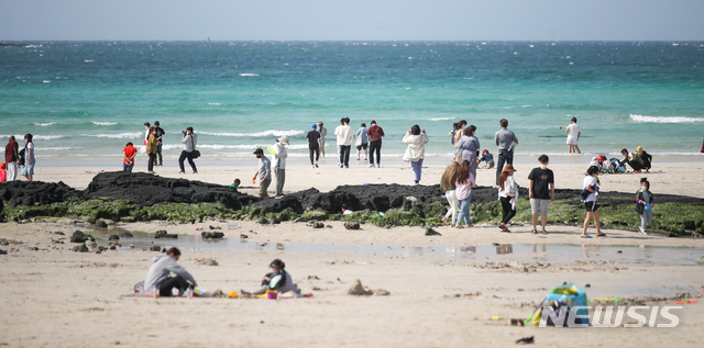 [제주=뉴시스]우장호 기자 = 코로나19 확산세가 전국적으로 이어지고 있는 25일 오후 제주시 한림읍 협재해수욕장을 찾은 관광객들이 푸른 바다를 감상하며 잠시 여유를 즐기고 있다. 질병관리청 중앙방역대책본부는 코로나19 신규 확진자가 이날 0시 기준 644명 발생했다고 밝혔다. 2021.04.25. woo1223@newsis.com