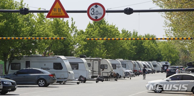 [청주=뉴시스] 이민우 기자 = 25일 충북 청주시 흥덕구 옥산면 한 공영주차장 3m 높이 제한시설을 통과한 카라반들이 일렬로 주차돼있다. 2021.04.26. lmw3837@newsis.com *재판매 및 DB 금지