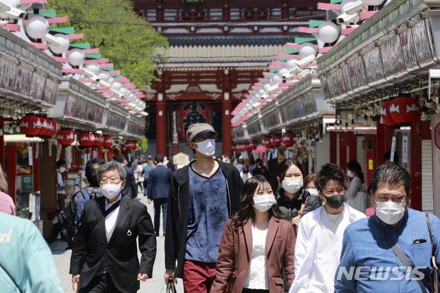 [도쿄=AP/뉴시스]26일 일본 도쿄의 아사쿠사 지구에서 코로나19 확산을 막기 위해 마스크를 쓴 시민들이 거리를 거닐고 있다. 일본은 2020 도쿄올림픽을 3개월 남기고 늘어가는 코로나19를 억제하기엔 기간이 충분하지 않을 것이라는 회의적인 시각 속에 25일 오사카부와 도쿄도, 효고현, 교토부 등 4개 도부현에 긴급사태 선언을 재선포했다. 2021.04.26. 