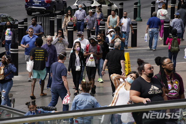 [라스베이거스=AP/뉴시스]미국 질병통제예방센터(CDC)가 코로나19 백신을 완전 접종한 경우 야외에서 마스크를 쓰지 않아도 된다고 발표한 이후인 지난 4월27일(현지시간) 미 네바다주 라스베이거스 거리에 마스크를 쓰거나 쓰지 않은 사람들이 혼재해 있다. 2021.06.30.