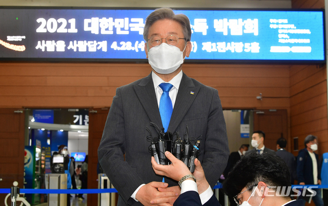 [고양=뉴시스]경기사진공동취재단 = 이재명 경기도지사가 28일 오전 경기도 고양시 킨텍스에서 열린 '2021 대한민국 기본소득 박람회'에 참석해 취재진의 질문에 답하고 있다. 2021.04.28. photo@newsis.com