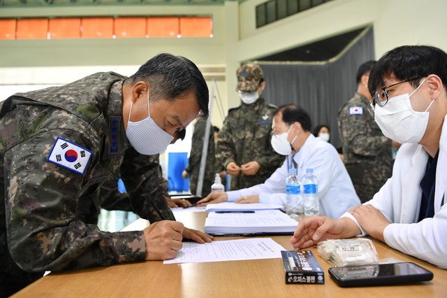 [서울=뉴시스]이성용 공군참모총장이 28일 충남 계룡대 체육관에 마련된 코로나19 예방접종 센터에서 아스트라제네카(AZ) 백신 접종을 받기 위해 접종 일정과 주의사항 등이 담긴 예방접종 내역서를 확인하고 있다. (사진=공군 제공) 2021.04.28. photo@newsis.com *재판매 및 DB 금지