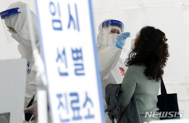 [서울=뉴시스]홍효식 기자 = 코로나19 신규 확진자가 775명으로 집계된 28일 서울 송파구 올림픽공원 앞에 마련된 임시선별진료소에서 의료진이 시민들의 검체를 채취하고 있다. 2021.04.28. yesphoto@newsis.com