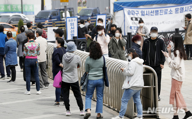 [서울=뉴시스]홍효식 기자 = 코로나19 신규 확진자가 775명으로 집계된 28일 서울 송파구 올림픽공원 앞에 마련된 임시선별진료소에서 시민들이 검사를 받기 위해 길게 줄지어 기다리고 있다. 2021.04.28. yesphoto@newsis.com
