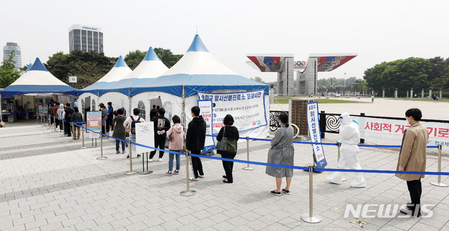 [서울=뉴시스]홍효식 기자 = 코로나19 신규 확진자가 775명으로 집계된 28일 서울 송파구 올림픽공원 앞에 마련된 임시선별진료소에서 시민들이 검사를 받기 위해 길게 줄지어 기다리고 있다. 2021.04.28. yesphoto@newsis.com