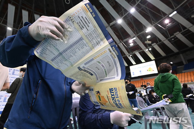 [수원=뉴시스]김종택기자 = 28일 오후 경기도 수원시 장안구 수원실내체육관에서 열린 '2021 수원시 일자리 박람회'에서 구직자들이 안내문을 살펴보고 있다. 2021.04.28. jtk@newsis.com