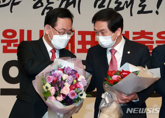 [서울=뉴시스]김진아 기자 = 김기현(오른쪽) 국민의힘 신임 원내대표 30일 서울 여의도 국회도서관 대강당에서 열린 국민의힘 원내대표 선출을 위한 의원총회에서 주호영 전 원내대표에게 축하받고 있다. (공동취재사진) 2021.04.30. photo@newsis.com