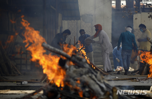 [뉴델리=AP/뉴시스]30일(현지시간) 인도 뉴델리의 한 화장터에서 친척들이 마지막 의식을 치르면서 코로나19 희생자를 화장하고 있다. 2021.05.01.