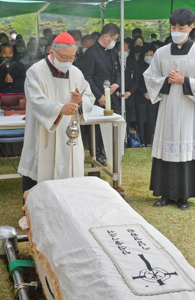 [용인=뉴시스]사진공동취재단 = 故정진석 추기경 하관예절이 열린 1일 오후 서울대교구 용인공원묘원 내 성직자 묘역에서 염수정 추기경이 정 추기경 관에 향로로 축복하고 있다. 2021.05.01. photo@newsis,com