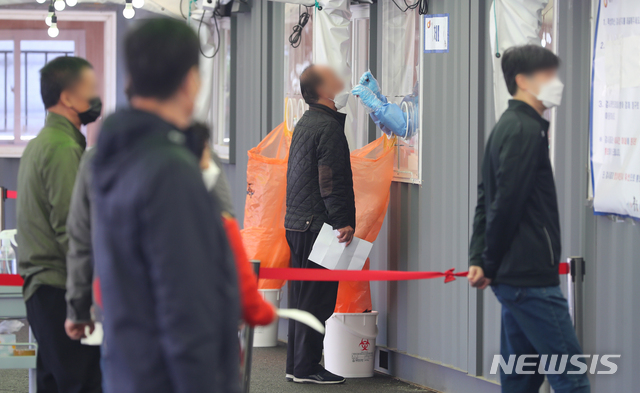 [서울=뉴시스]배훈식 기자 = 0시 기준 코로나19 신규 확진자 수가 606명을 기록한 2일 오전 서울 중구 서울역광장에 마련된 코로나19 중구 임시선별검사소에서 한 시민이 검사를 받고 있다. 2021.05.02. dahora83@newsis.com