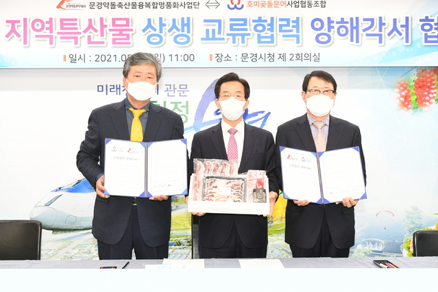문경약돌축산물명품화사업단과 포항호미곶돌문어사업협동조합 관계자들이 문경시청에서 '지역특산물 상생 교류협력을 위한 업무협약'을 체결하고 있다. (사진=문경시 제공) *재판매 및 DB 금지