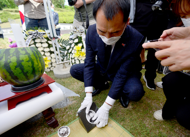 [광주=뉴시스]김혜인 기자 = 전재수 열사 41주기 사진묘비 제막식·추모제가 열린 5일 오전 광주 북구 운정동 국립5·18민주묘지에서 유족 전재룡(60)씨가 전 열사의 얼굴이 담긴 사진 묘비를 교체하고 있다. 2021.05.05.hyein0342@newsis.com 