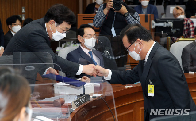 [서울=뉴시스]김진아 기자 = 김부겸 국무총리 후보자가 6일 오전 서울 여의도 국회에서 열린 인사청문회에서 선서문을 서병수 위원장에게 전달한 뒤 악수하고 있다. (공동취재사진) 2021.05.06. photo@newsis.com