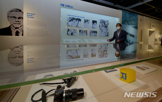 [광주=뉴시스] 변재훈 기자 = 옛 전남도청 복원추진단 관계자가 6일 광주 동구 옛 전남도청 별관 2층에서 외신 기자 노먼 소프가 5·18 민주화운동 당시 계엄군의 최후진압작전 전후 상황을 촬영한 사진 자료를 설명하고 있다. 2021.05.06. wisdom21@newsis.com