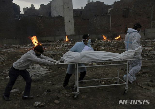 [뉴델리=AP/뉴시스]지난 6일(현지시간) 인도 뉴델리 임시 화장터에서 사람들이 코로나19 희생자를 화장하기 위해 시신을 옮기고 있다. 2021.05.07.