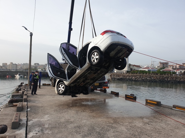 제주해양경찰서가 8일 오전 제주시 삼양3동 포구에서 크레인을 이용해 바다로 추락한 승용차를 인양하고 있다. (사진=제주해양경찰서 제공) 2021.05.08, *재판매 및 DB 금지