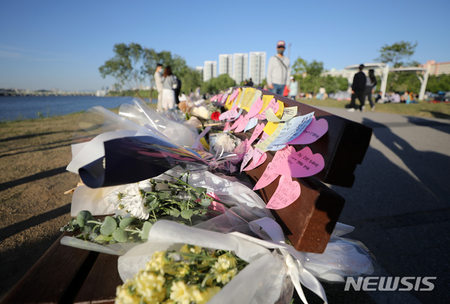 [서울=뉴시스]고범준 기자 = 지난 9일 오후 서울 서초구 반포한강공원 수상택시 승강장 인근 벤치에 마련된 A(22)씨의 추모 공간에 시민들이 가져온 꽃과 메모 등이 놓여 있다. 2021.05.09. bjko@newsis.com