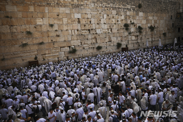 [예루살렘=AP/뉴시스] 10일 이스라엘군의 동예루살렘 점령기념일을 맞아 유대인 남성들이 유대인 기도처인 구시가지 서벽 앞에 모여 기도하고 있다 서벽 위 구릉에 템플 마운트 겸 알하람 알샤리프 종교단지가 있다
