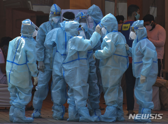 FILE - In this May 10, 2021, file photo, health workers and volunteers in personal protective suits wait to receive patients outside a COVID-19 hospital that was set up at a Sikh Gurdwara in New Delhi, India. The World Health Organization said Monday, May 10, that a worrisome variant was first detected in India may spread more easily. Scientists are still trying