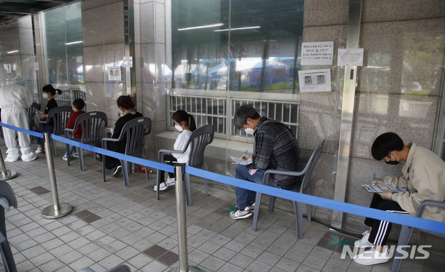 [서울=뉴시스]김형수 기자 =&nbsp; 0시 기준 국내 코로나19 신규확진자가 635명 발생한 12일 서울 시내 한 보건소 코로나19 선별진료소에서 검사를 받으려는 시민들이 문진표를 작성하고 있다. 2021.05.12. kyungwoon59@newsis.com