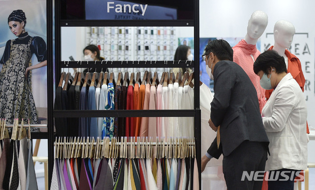 [대구=뉴시스]이무열 기자 = 12일 오전 대구 북구 산격동 엑스코에서 열린 ‘2021 대구국제섬유박람회’를 찾은 바이어가 부스에 진열된 제품을 살펴보고 있다. 14일까지 진행되는 이번 박람회는 국내외 194개 기업이 참가해 원사와 작물, 생활물품과 K-방역 소재 등 다양한 신소재 아이템을 선보인다. 2021.05.12. lmy@newsis.com