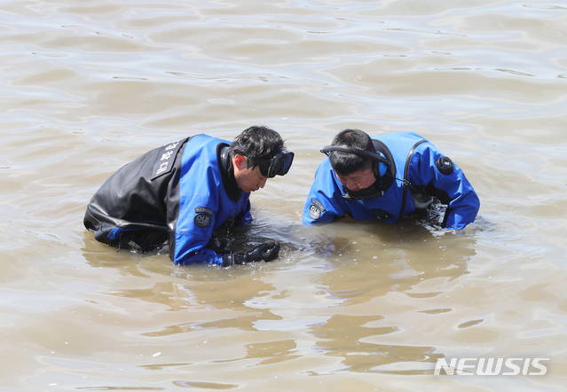 [서울=뉴시스]배훈식 기자 = 한강경찰대 대원들이 지난달 12일 오후 서울 서초구 반포한강공원 수상택시 승강장 인근에서 A씨의 친구 B씨의 휴대전화 수색작업을 하고 있다. 2021.05.12. dahora83@newsis.com