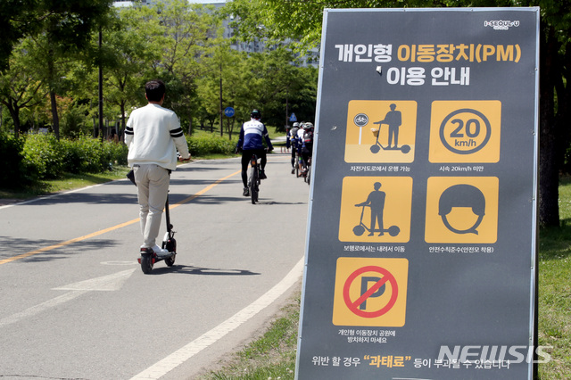 [서울=뉴시스]김병문 기자 = 헬멧 의무 착용 등 전동킥보드 이용조항 위반에 대한 범칙금 부과 강화를 하루 앞둔 지난 12일 오후 서울 여의도 한강공원에서 시민이 전동킥보드를 타고 있다. 2021.05.12. dadazon@newsis.com