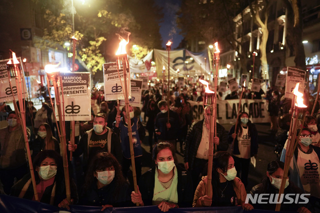 [부에노스아이레스=AP/뉴시스]세계 간호사의 날인 12일(현지시간) 아르헨티나 부에노스아이레스에서 간호사들이 급여 인상과 근무 환경 개선 등을 요구하며 횃불 시위를 하고 있다. 2021.05.13.
