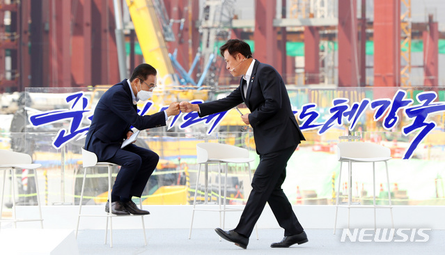 [평택=뉴시스]추상철 기자 = 김기남(왼쪽) 삼성전자 부회장이 13일 오후 경기 평택시 삼성전자 평택단지 3라인 건설현장에 마련된 야외무대에서 열린 'K-반도체 전략 보고'에 참석해 발표를 끝낸 박정호 SK하이닉스 부회장과 주먹인사를 나누고 있다. 2021.05.13. scchoo@newsis.com
