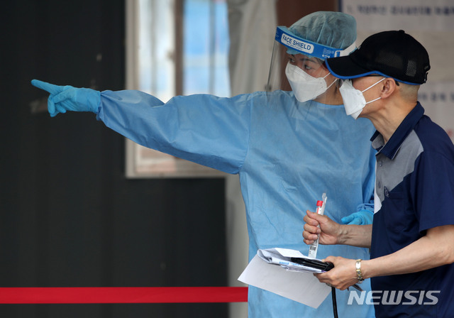 [서울=뉴시스]박주성 기자 = 지난 14일 오전 서울 중구 서울역 광장 임시선벌검사소에서 시민이 의료진의 설명을 들으며 검사를 받으러 가고 있다. 2021.05.14. park7691@newsis.com