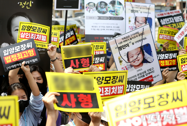 [서울=뉴시스]정병혁 기자 =  '정인이' 양부모의 1심 선고 공판이 열린 14일 오후 서울 양천구 서울남부지방법원 입구에서 시민들이 양모가 탑승한 것으로 보이는 호송차를 향해 손피켓을 들고 항의하고 있다. 2021.05.14. jhope@newsis.com