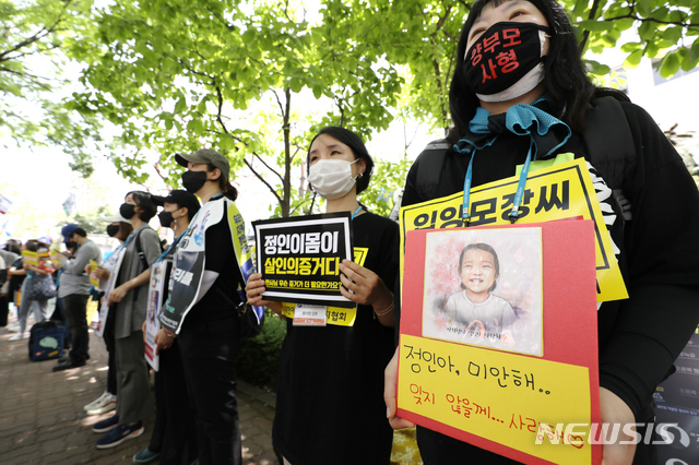 [서울=뉴시스]정병혁 기자 =  '정인이'의 양부모의 1심 선고 공판이 열린 14일 오후 서울 양천구 서울남부지방법원 입구에서 시민들이 강력한 처벌을 촉구하는 피켓을 들고 있다. 2021.05.14. jhope@newsis.com