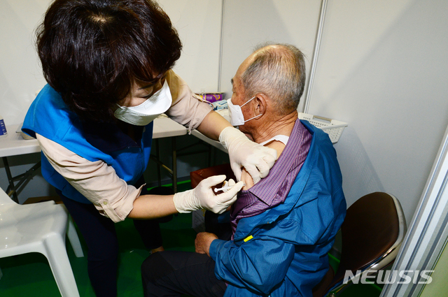 [남해=뉴시스]차용현 기자 = 지난 14일 오전 경남 남해군 남해읍 소재 남해문화체육센터에서 한 의료진이 75세 이상 어르신들을 대상으로 코로나 19 백신을 접종하고 있다. 2021.05.15. con@newsis.com