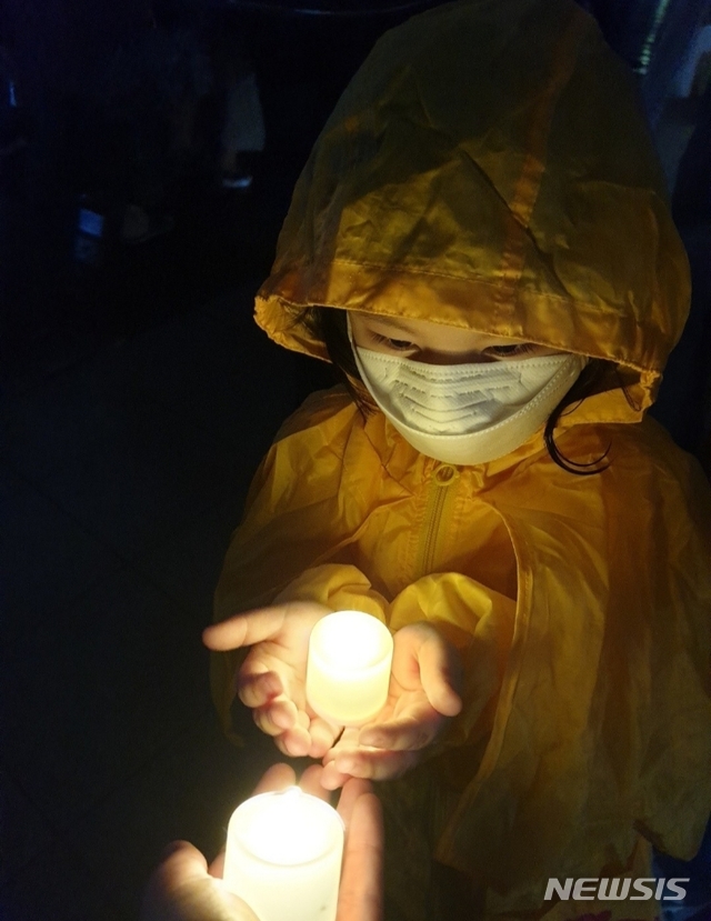 [김포=뉴시스]정일형 기자=15일 오후 8시 장기동 라베이체에서 열린 김포검단교통시민연대 3번째 촛불집회에서 5살 아이가 비를 맞으면서 촛불을 들고 있다. (사진은 김포검단교통시민연대 제공) jih@newsis.com