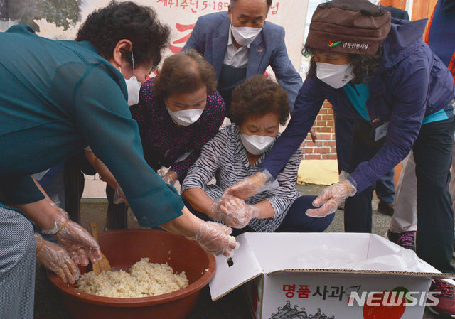 [광주=뉴시스] 변재훈 기자 = 제41주년 5·18민중항쟁기념행사위원회가 5·18 41주기를 이틀 앞둔 16일 오후 광주 서구 양동 행정복지센터에서 '주먹밥'을 만들어 나누는 기념 행사를 열고 있다. 항쟁 당시 양동시장 노점상인들이 41년 전 시민군에게 건넸던 주먹밥을 만드는 장면을 재현하고 있다. 2021.05.16. wisdom21@newsis.com