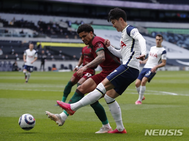 Tottenham's Son Heung-min, right, and Wolverhampton Wanderers' Ki-Jana Hoever challenge for the ball during the English Premier League soccer match between Tottenham Hotspur and Wolverhampton Wanderers at Tottenham Hotspur Stadium in London, England, Sunday, May 16, 2021.(AP Photo/Andrew Couldridge, Pool)