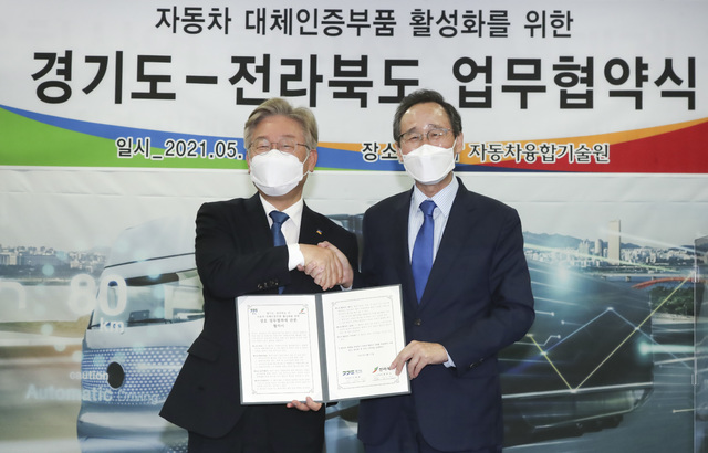 [전주=뉴시스] 17일 전북 군산 자동차융합기술원에서 열린 전라북도-경기도 자동차 대체인증부품 활성화를 위한 업무협약식에 송하진 전북도지사(오른쪽)와 이재명 경기도지사가 체결식을 갖고 있다. 2021.05.17 (사진= 전라북도청 제공) photo@newsis.com *재판매 및 DB 금지
