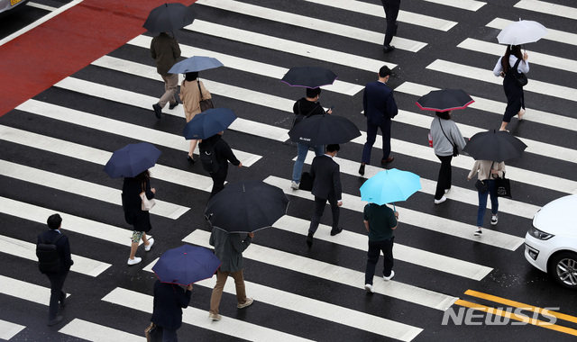 [서울=뉴시스]이영환 기자 = 이슬비가 내리고 있는 지난 17일 오전 서울 영등포구 여의도역 인근에서 시민들이 우산을 쓰고 걸어가고 있다. 2021.05.17. 20hwan@newsis.com