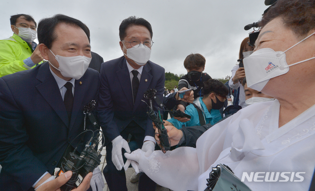 [광주=뉴시스] 변재훈 기자 = 5·18민주화운동 41주기를 하루 앞둔 17일 광주 북구 운정동 국립 5·18민주묘지에서 열린 5·18민중항쟁 추모제에 참석한 국민의힘 (사진 왼쪽부터)성일종·정운천 의원이 유족을 만나 악수하고 있다. 2021.05.17. wisdom21@newsis.com