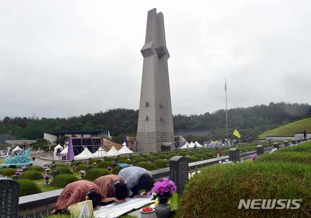 [광주=뉴시스] 김혜인 기자 = 5·18민주화운동 41주기를 하루 앞둔 17일 광주 북구 운정동 국립 5·18민주묘지에서 유족들이 열사 묘에 절을 하고 있다. 2021.05.17. hyein0342@newsis.com