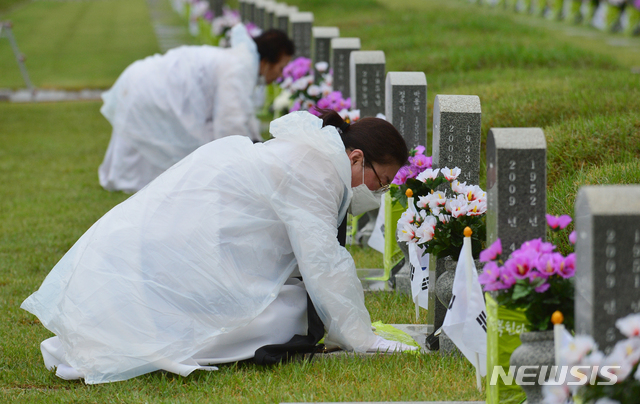 [광주=뉴시스] 김혜인 기자 = 5·18민주화운동 41주기를 하루 앞둔 17일 광주 북구 운정동 국립 5·18민주묘지에서 유족들이 열사 묘 앞에 절을 하고 있다. 2021.05.17. hyein0342@newsis.com