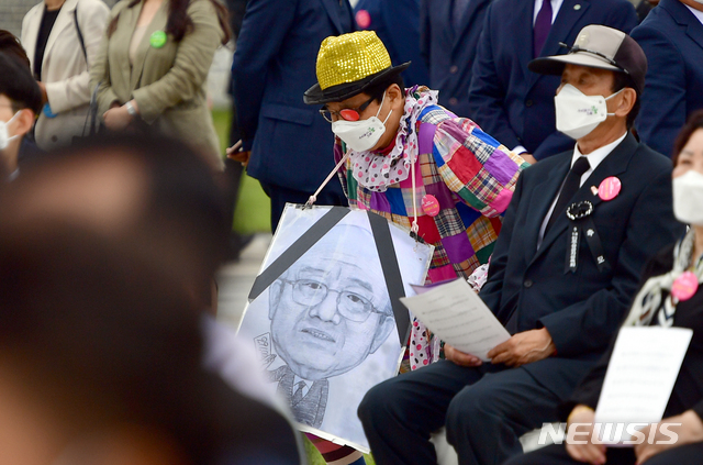 [광주=뉴시스]류형근 기자 = 18일 오전 광주 북구 운정동 국립5·18민주묘지에서 '우리들의 오월'을 주제로 41주기 기념식이 열린 가운데 한 참석자가 전두환 그림을 목에 걸고 행사에 참석하고 있다. 2021.05.18. hgryu77@newsis.com